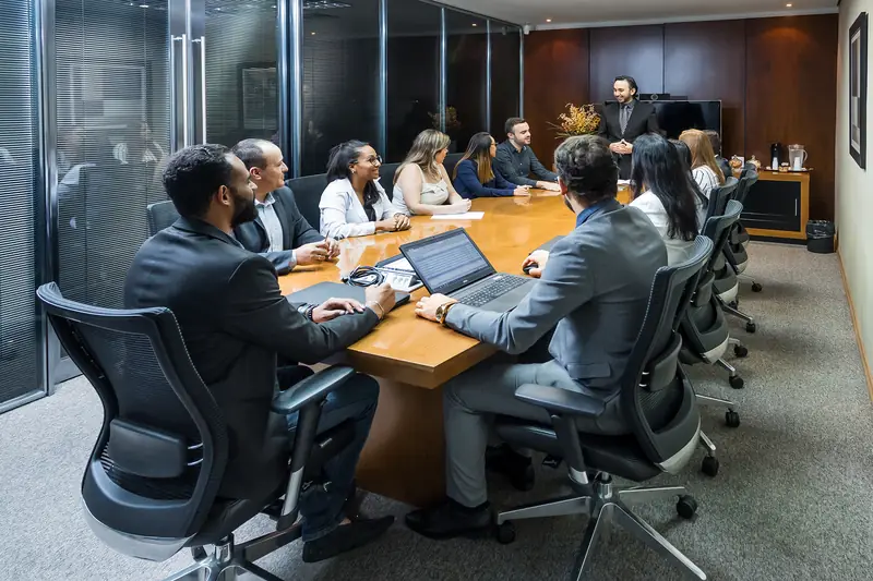 Equipe reunida em volta da mesa da sala de reunião